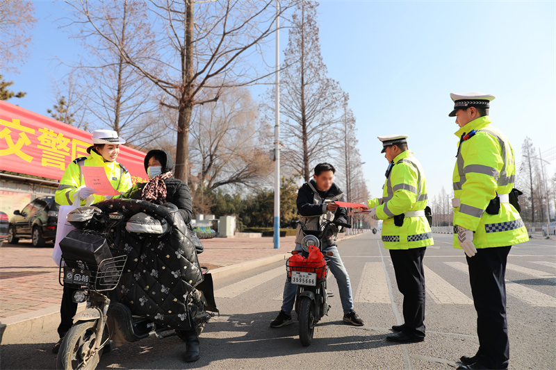 宣传队员街头为市民宣讲“一盔一带”安全常识.jpg