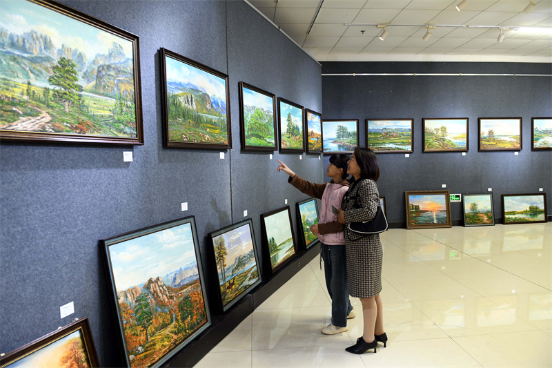 5月4日，市民带着孩子在山东省临沂市郯城县文体中心展览馆观看尤敏杰展览的油画作品。.JPG