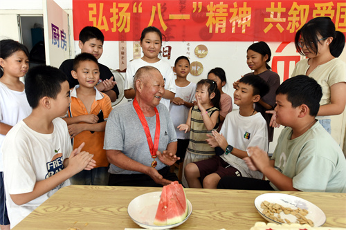 8月1日，在山东省临沂市郯城县马头镇玉带社区“老兵驿站”，退伍老战士高广忠（中）为孩子们讲军旅故事。.JPG